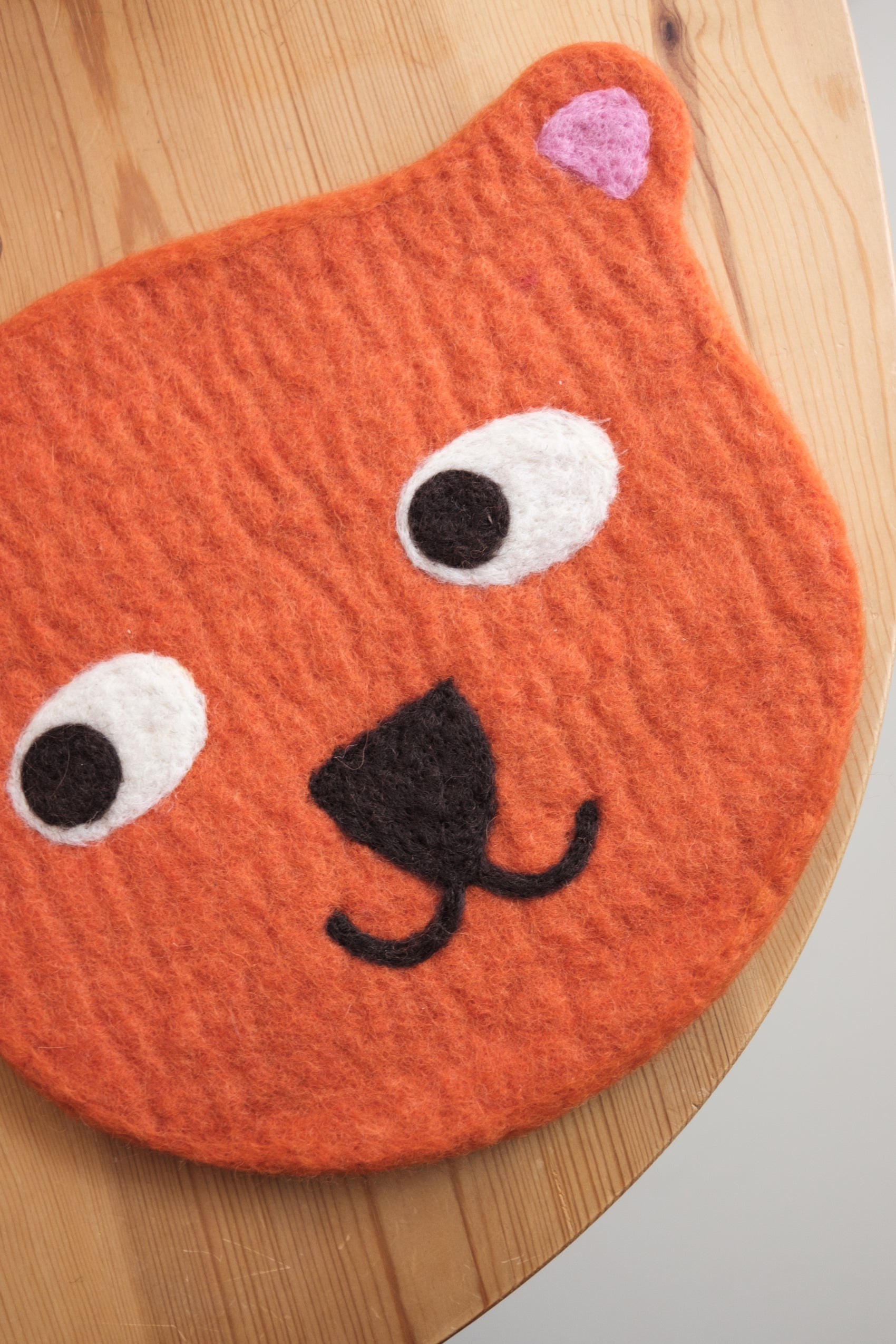 Sitteunderlag i ull - oransje bjørn