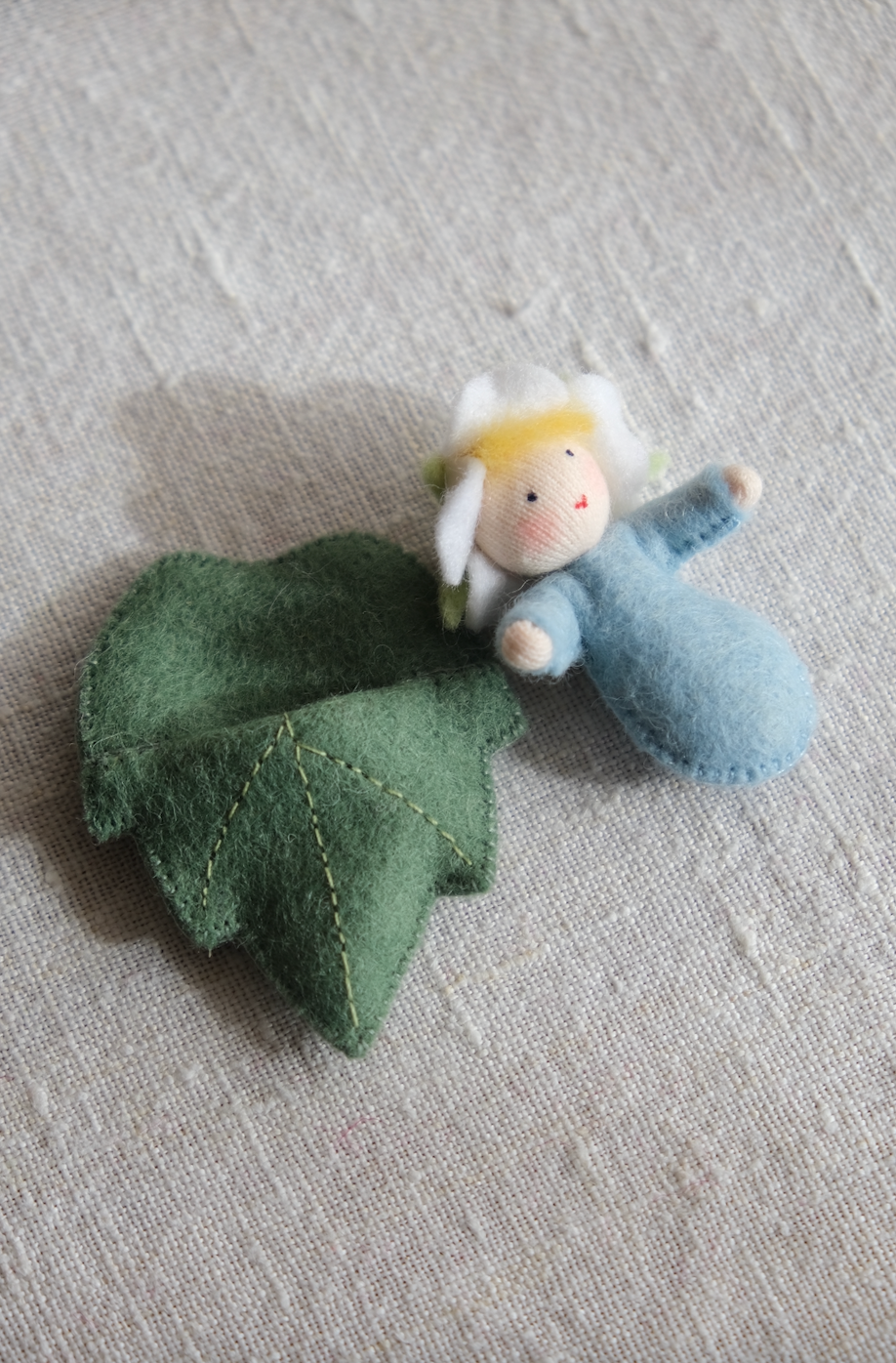 Blomsterbaby i bladsovepose - ullfigur