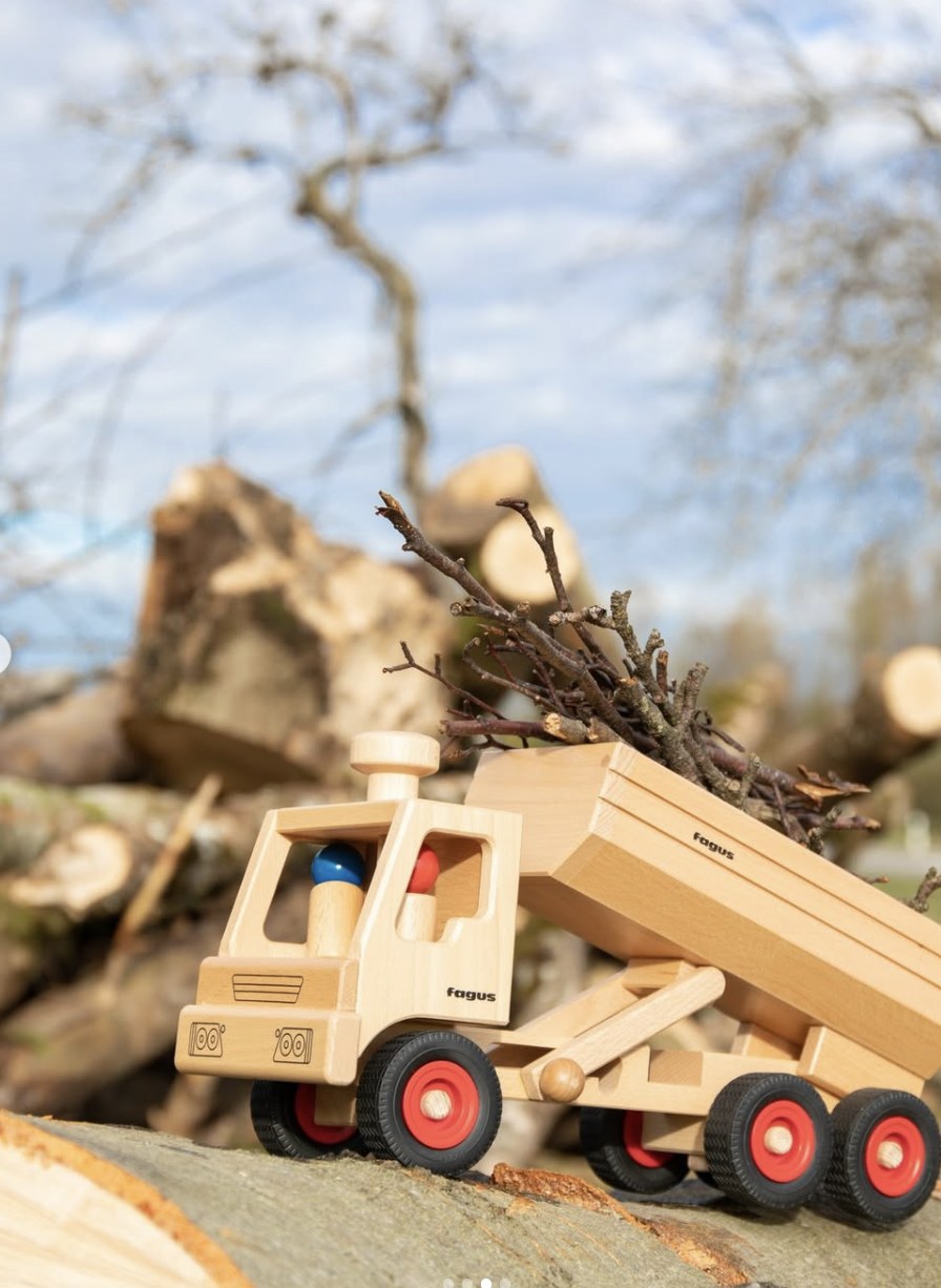 Fagus lastebil i tre som tipper et lass med kvister